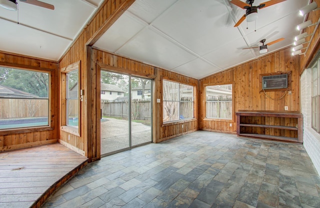 unfurnished sunroom featuring ceiling fan, lofted ceiling, and a wall mounted air conditioner