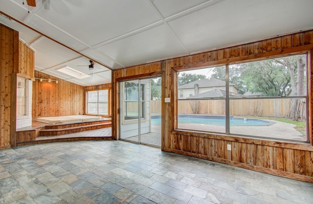 unfurnished sunroom with ceiling fan