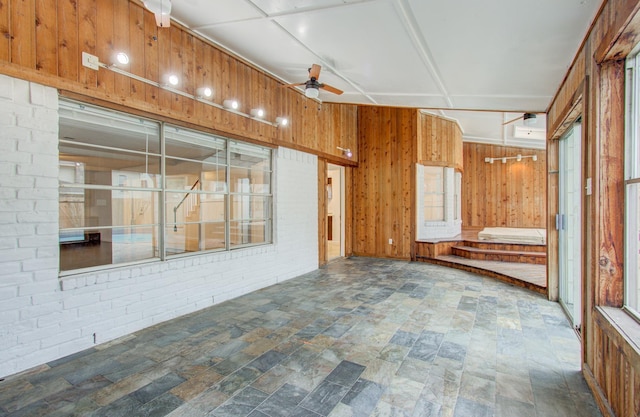 unfurnished sunroom featuring ceiling fan