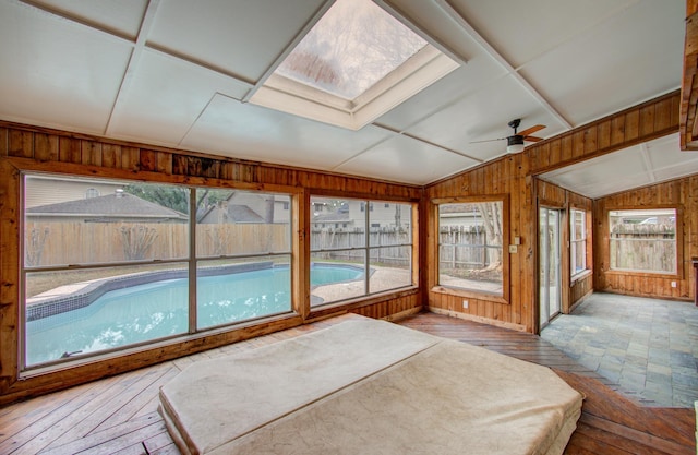 sunroom featuring vaulted ceiling with skylight and ceiling fan