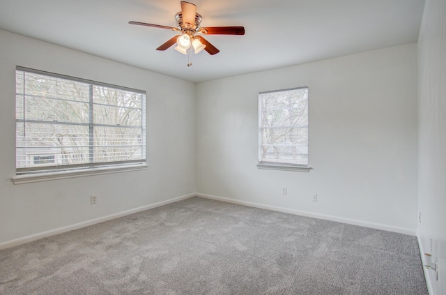 carpeted spare room featuring ceiling fan