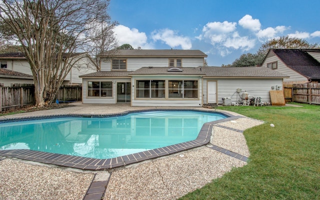 view of swimming pool featuring a sunroom, a patio area, and a lawn