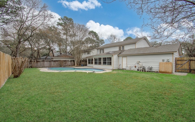 back of property featuring a fenced in pool, a yard, and a sunroom