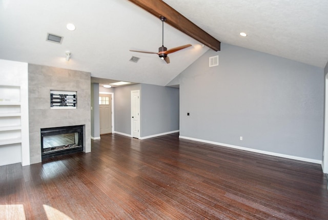 unfurnished living room with a tile fireplace, dark hardwood / wood-style floors, vaulted ceiling with beams, ceiling fan, and built in shelves