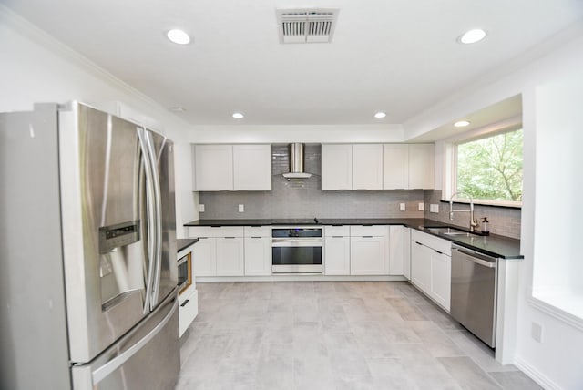 kitchen featuring white cabinetry, sink, wall chimney exhaust hood, and appliances with stainless steel finishes