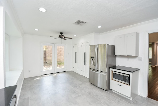 kitchen with white cabinetry, appliances with stainless steel finishes, ornamental molding, and french doors