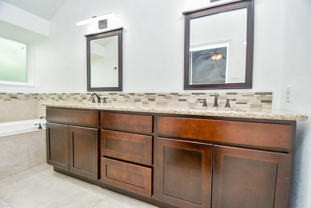 bathroom with vanity, backsplash, tile patterned floors, and tiled bath