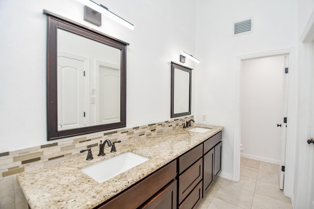 bathroom with tile patterned flooring, toilet, vanity, and decorative backsplash