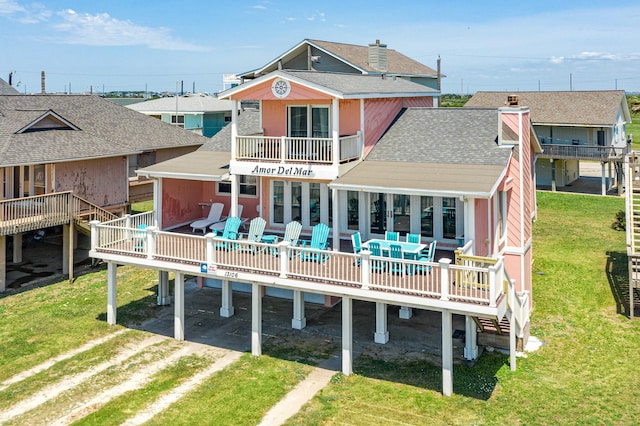 back of house featuring a deck and a lawn