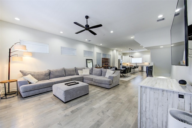 living room featuring ceiling fan and light hardwood / wood-style flooring