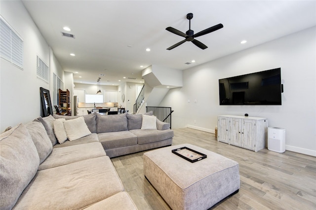 living room featuring stairs, light wood-style flooring, visible vents, and recessed lighting