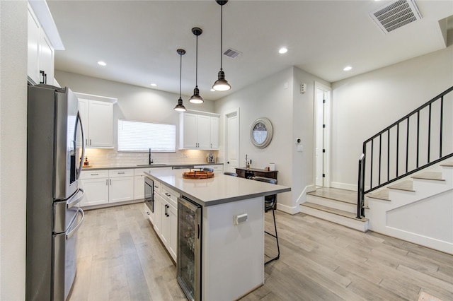 kitchen featuring a kitchen island, white cabinetry, and appliances with stainless steel finishes