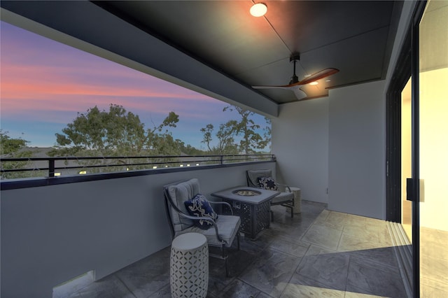 balcony at dusk with ceiling fan and a fire pit