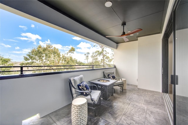 balcony with ceiling fan and an outdoor fire pit