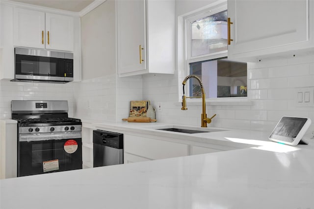 kitchen with white cabinetry, sink, decorative backsplash, light stone counters, and stainless steel appliances