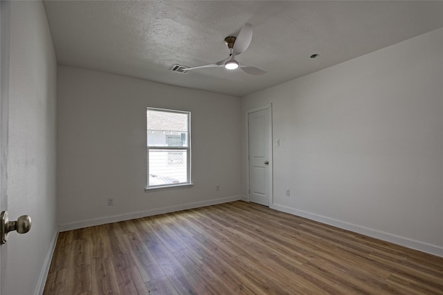 unfurnished room featuring ceiling fan, hardwood / wood-style floors, and a textured ceiling