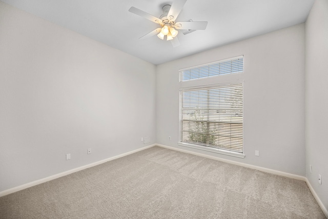 carpeted spare room featuring ceiling fan