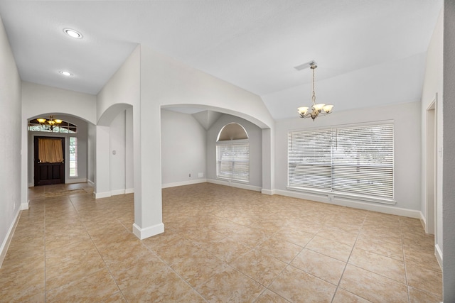 interior space with lofted ceiling, a notable chandelier, light tile patterned floors, and plenty of natural light