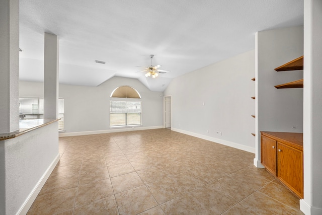 unfurnished living room featuring ceiling fan, lofted ceiling, and light tile patterned floors