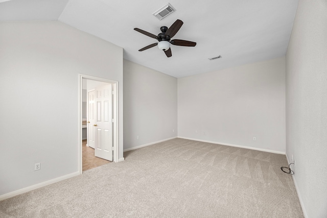 empty room with lofted ceiling, light carpet, and ceiling fan