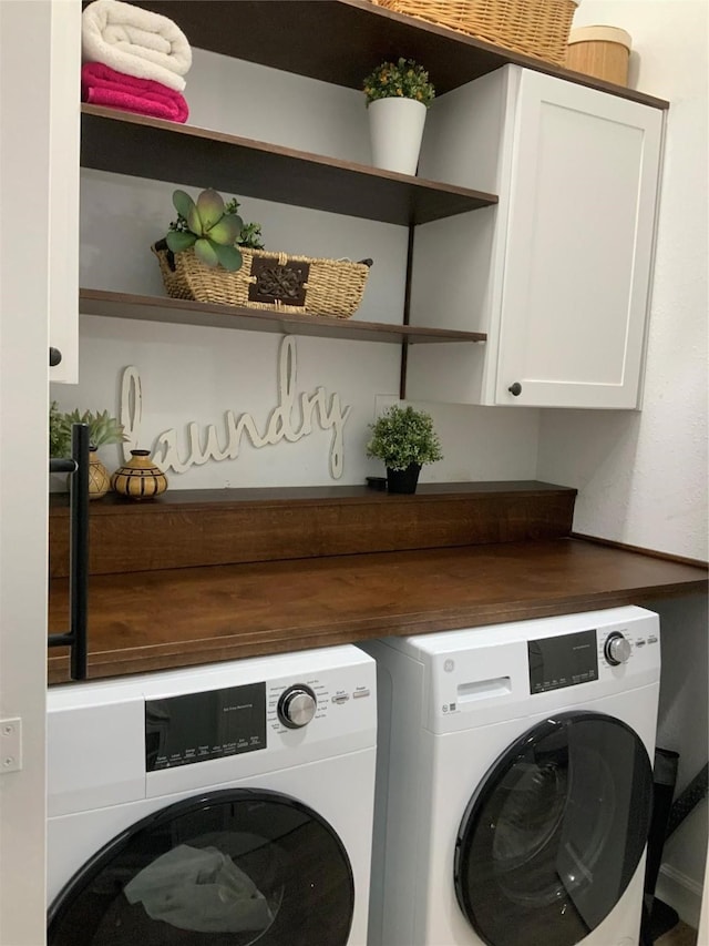 washroom featuring separate washer and dryer and cabinets