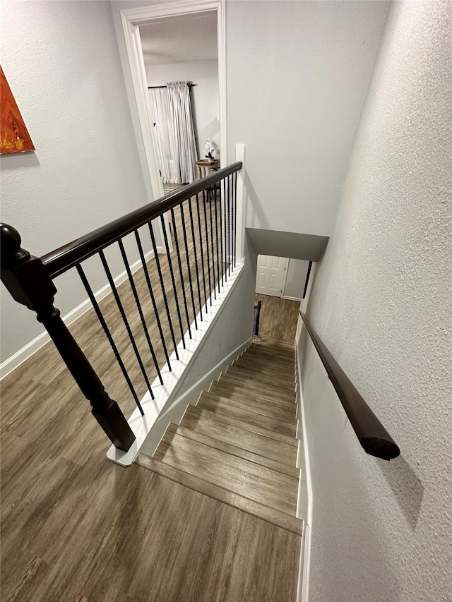 stairs featuring hardwood / wood-style floors