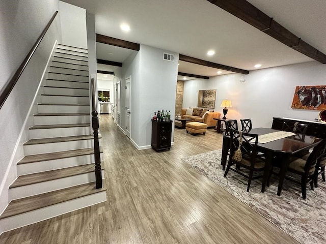 dining room featuring hardwood / wood-style flooring and beamed ceiling