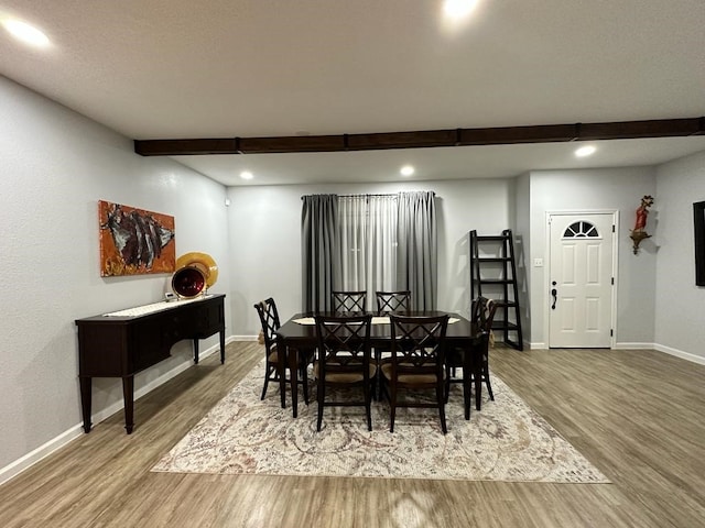 dining room featuring beam ceiling and hardwood / wood-style flooring