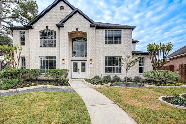 view of front of property featuring french doors and a front lawn