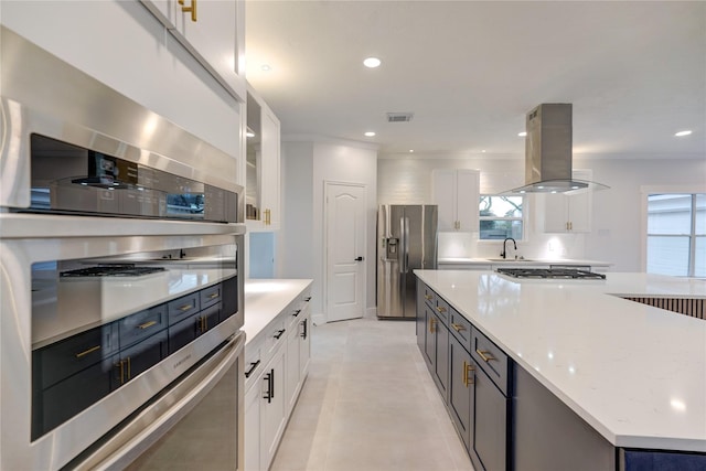 kitchen featuring white cabinetry, a center island, appliances with stainless steel finishes, ornamental molding, and island exhaust hood