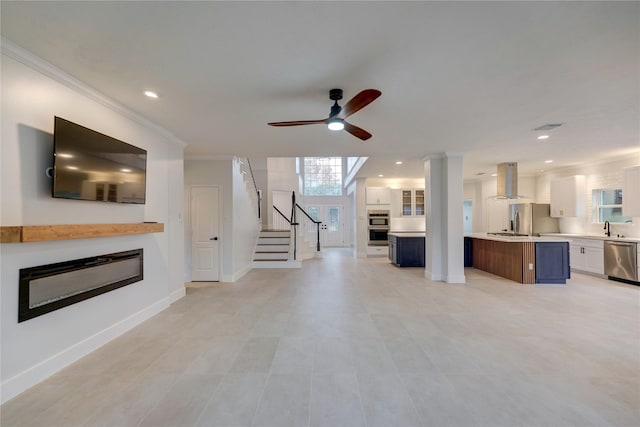 unfurnished living room featuring ornamental molding and ceiling fan