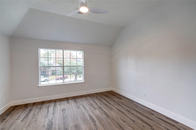 empty room with lofted ceiling, light hardwood / wood-style floors, and ceiling fan