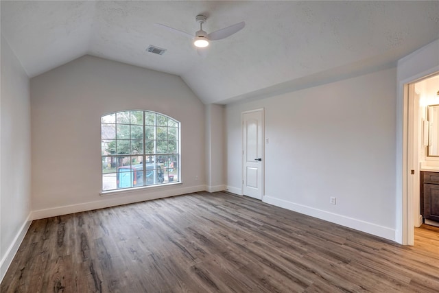 unfurnished room featuring wood-type flooring, vaulted ceiling, a textured ceiling, and ceiling fan