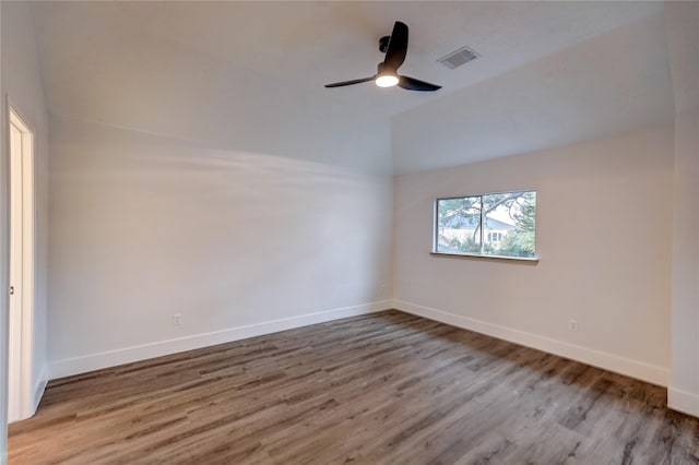 spare room featuring hardwood / wood-style flooring, vaulted ceiling, and ceiling fan