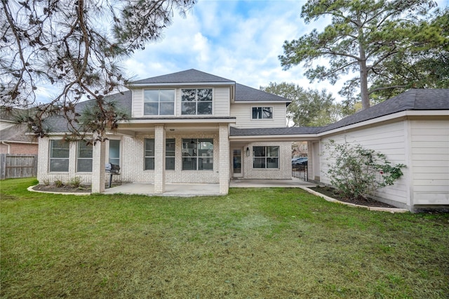 rear view of house with a patio and a lawn