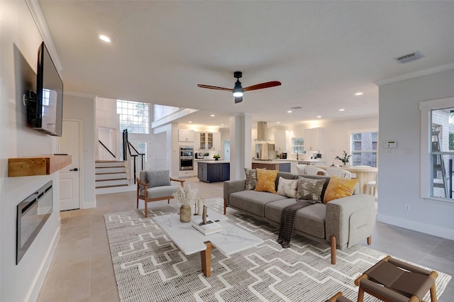 living room featuring crown molding, plenty of natural light, light tile patterned floors, and ceiling fan