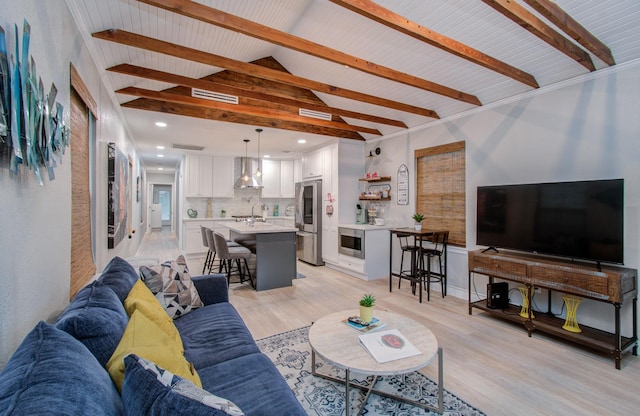 living room with lofted ceiling with beams and light hardwood / wood-style flooring