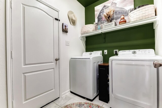 clothes washing area with light tile patterned floors and washing machine and clothes dryer