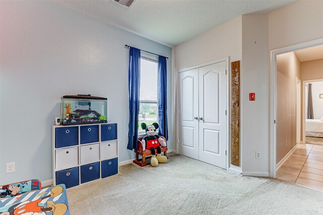 playroom featuring a textured ceiling and carpet