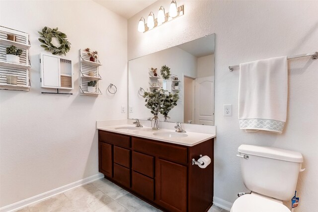 bathroom with tile patterned flooring, vanity, and toilet