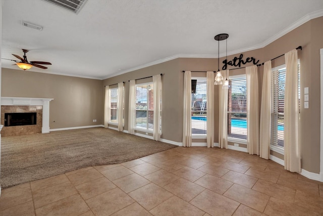 unfurnished living room featuring crown molding, ceiling fan, a fireplace, and light carpet