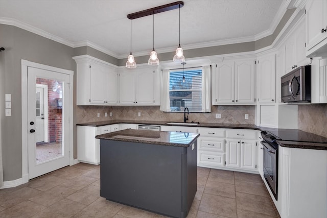 kitchen featuring sink, stainless steel appliances, white cabinets, a kitchen island, and decorative backsplash