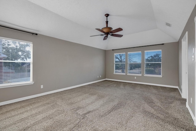 empty room with ceiling fan, a healthy amount of sunlight, and vaulted ceiling