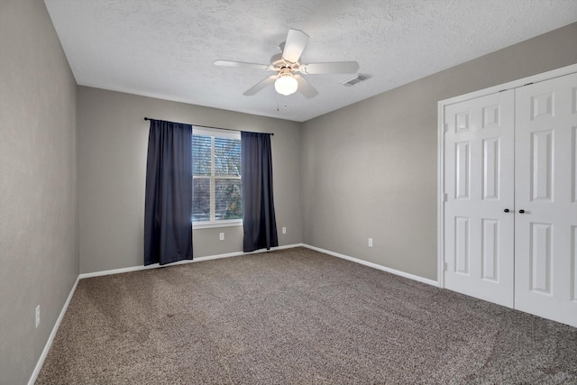 spare room featuring ceiling fan, carpet, and a textured ceiling