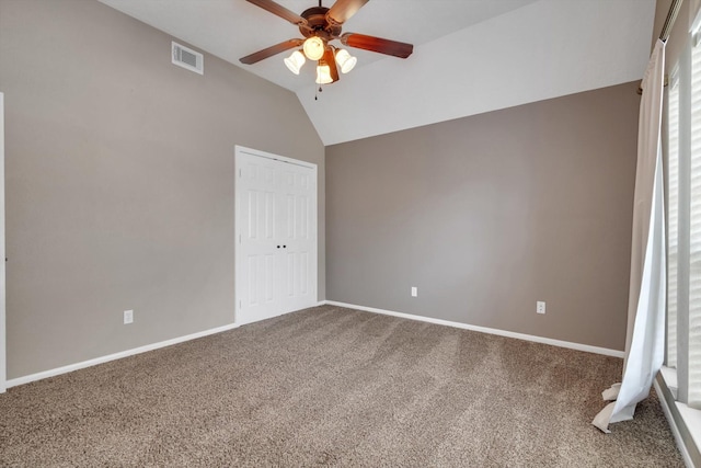 unfurnished bedroom with lofted ceiling, a closet, ceiling fan, and carpet flooring