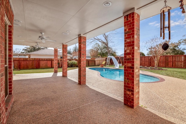 view of swimming pool featuring a water slide, ceiling fan, and a patio area