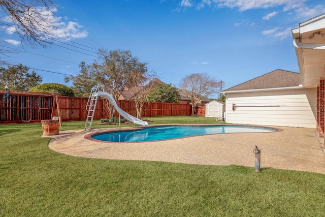 view of pool with a water slide, a yard, and a shed