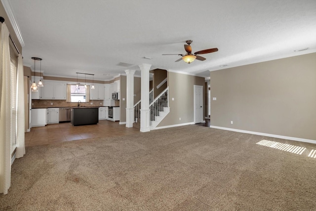 unfurnished living room with sink, ornamental molding, and carpet