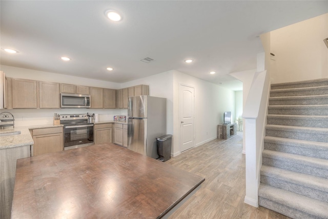 kitchen with appliances with stainless steel finishes, recessed lighting, light brown cabinets, and visible vents