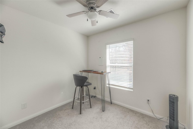 office space with light carpet, ceiling fan, and baseboards